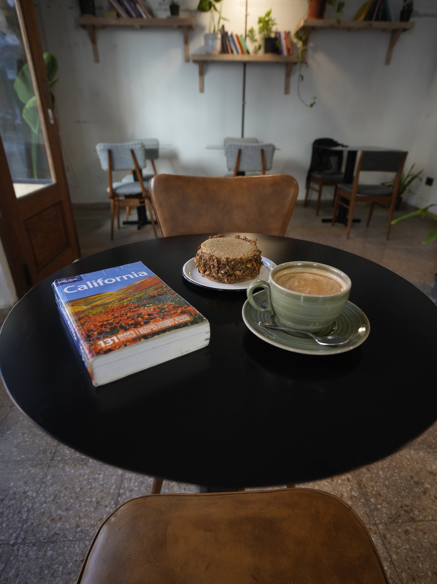 Mesa con libro, café y alfajor de semillas en Afán